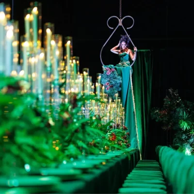 Green themed event with lady hanging from chandelier