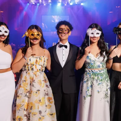Five people pose for a photo with masks at a masquerade ball at Sydney Town Hall