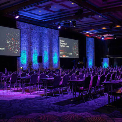 a room at The Star Gold Coast with tables and chairs and a projector screen